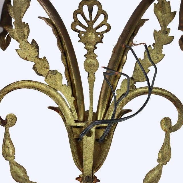 A pair of antique French Louis XV style double light electric wall sconces, crafted from bronze around the turn of the...