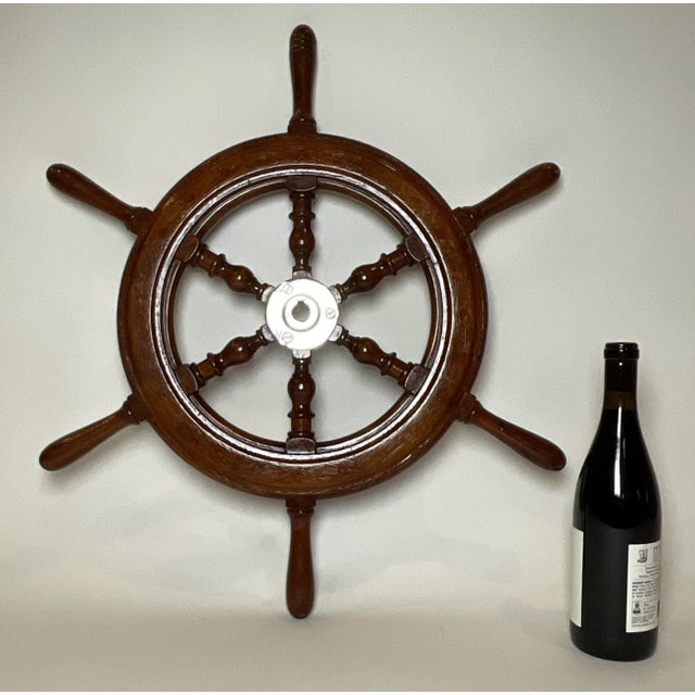 Mahogany boat wheel with a chrome plated hub and six turned spokes. Varnish finish. From a small craft. Weight: 6 lbs....