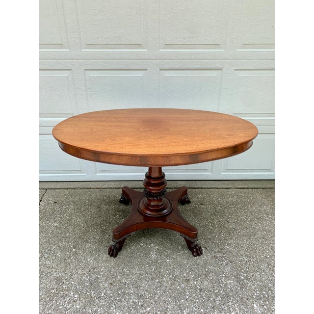 A stunning antique American Empire mahogany pedestal center table or console table with lion paw feet USA, late 19th...