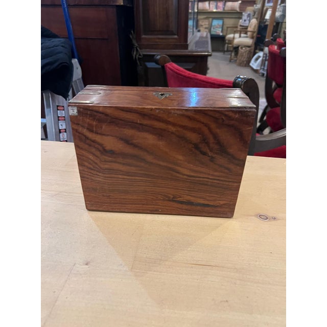 Beautiful vintage wooden jewelry box featuring a rich warm wood finish accented with brass corner details and a central...