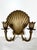 Vintage pair of brass shell candle sconces. Brass scallop shells with 2 candelabra arms each to hold candlesticks.