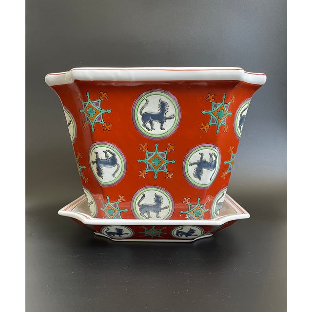 This vintage Chinese planter pot with matching tray features a repeating, hand-enameled design of Qilin and star motifs...