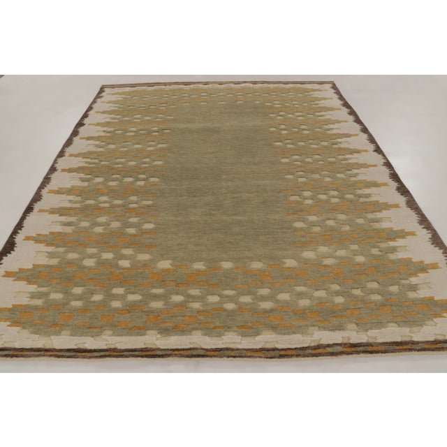 Hand-knotted in wool, this 8x10 Art Deco rug showcases a plush high-low texture with an earthy sage green center framed by...