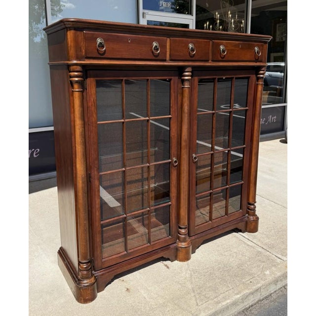 This Pennsylvania House Courtland Manor Two-Door Bookcase features a rich traditional wood finish, fluted column details,...