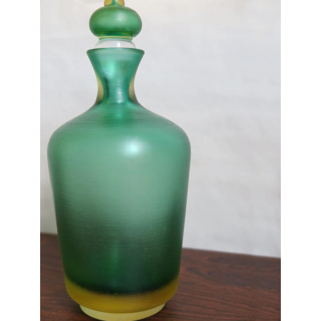 Bottle with stopper, Incisi series, in two-color submerged glass with surface entirely ground, produced by Venini, Venini...