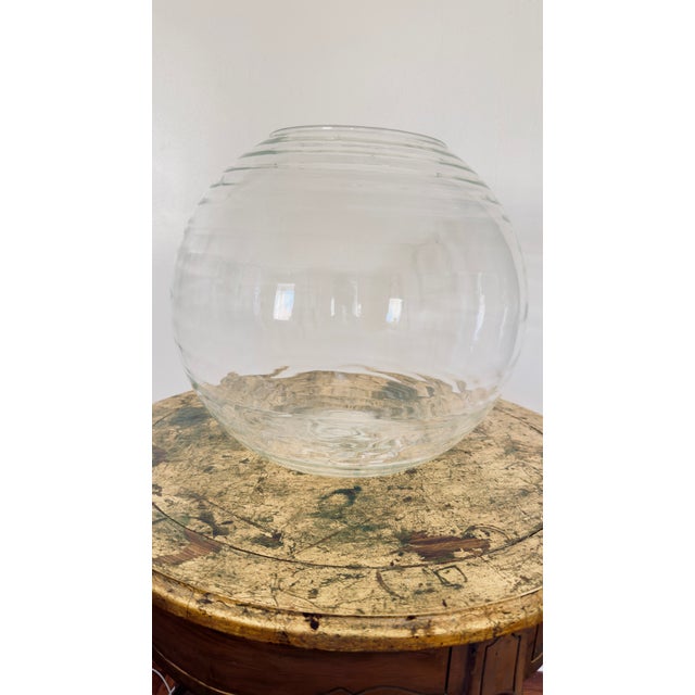 Large hand-blown clear glass vessel with a visible pontil mark on the base, indicating free-blown production rather than...
