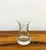 An elegant vintage hand-blown art glass vase featuring a graceful hourglass silhouette, a thick clear glass base, and a...