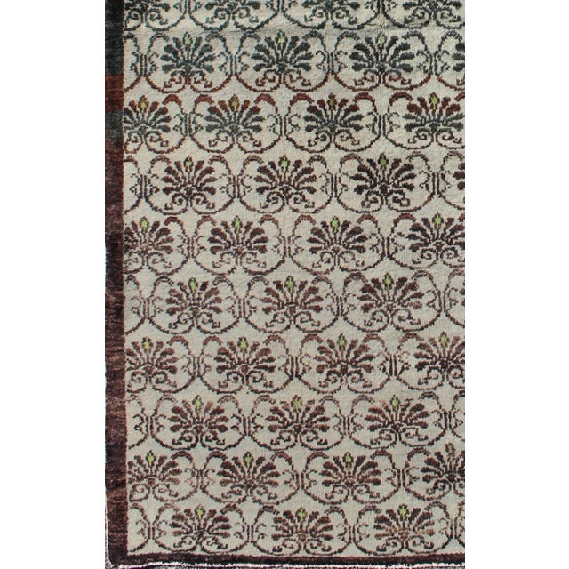 This Oushak carpet (circa mid-20th century) features an all-over pattern of interconnected, vertically-arranged vining...