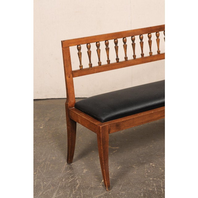 A vintage wooden bench with upholstered seat from US furniture maker and interior designer, Yale R. Burge. This well-...
