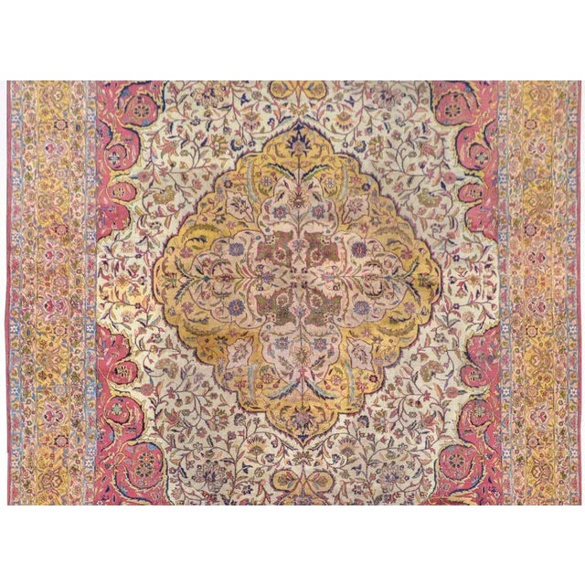 An outstanding early 20th century Persian Agra rug with an elaborate floral medallion woven in myriad colors on a gold...