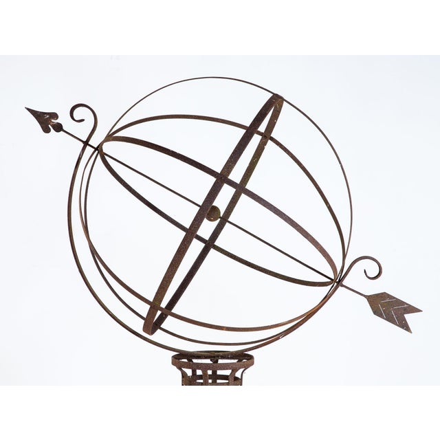 A striking English mid-20th century iron armillary sphere on an oversized scale and mounted on a complementary stand....