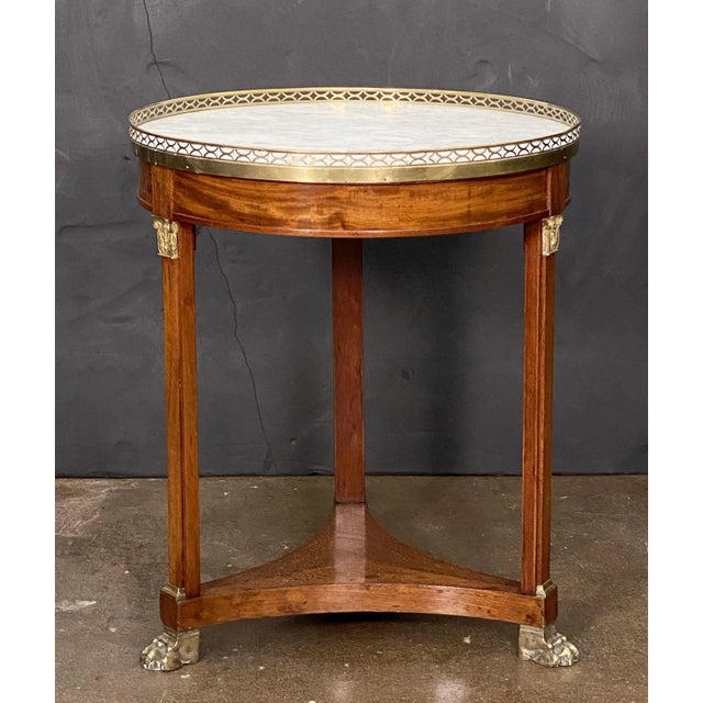 A handsome French round occasional table or gueridon in the Empire style, featuring a circular top of figured white marble...