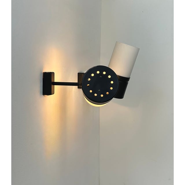 Pair of adjustable wall lights, each with a metal frame and an opaline glass diffuser, produced in France in the 1980s....