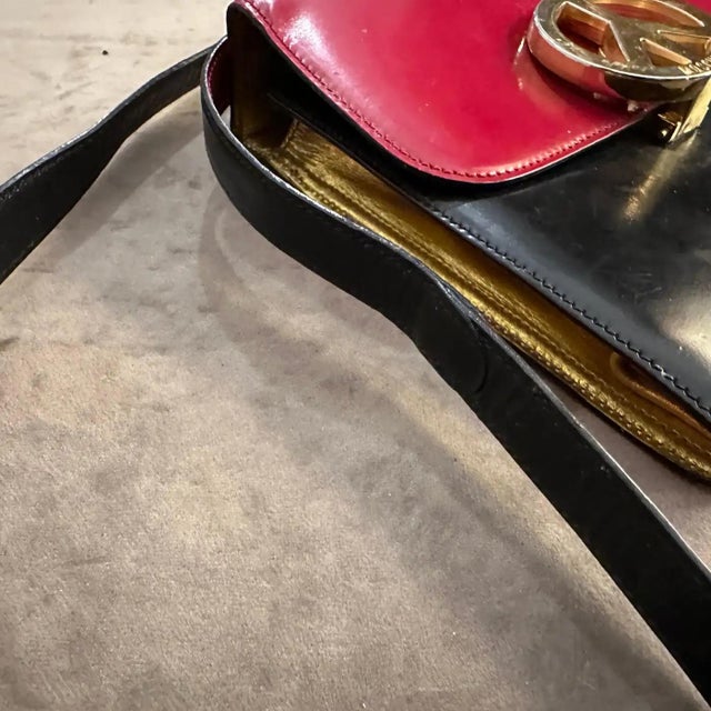 This 1980s vintage handbag is an iconic design by Franco Moschino. It reflects the playful and bold aesthetic Moschino is...