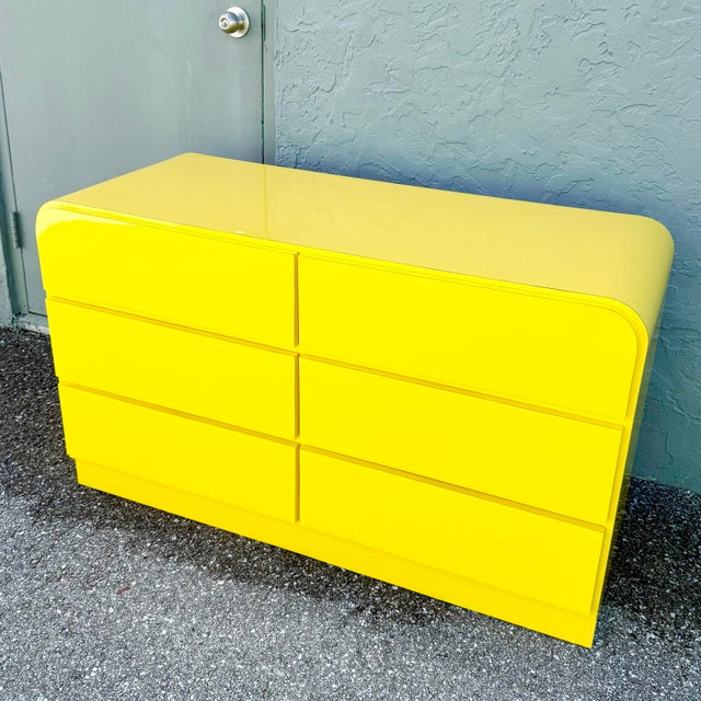 This striking Postmodern waterfall dresser makes a bold statement with its high-gloss canary yellow laminate finish and...