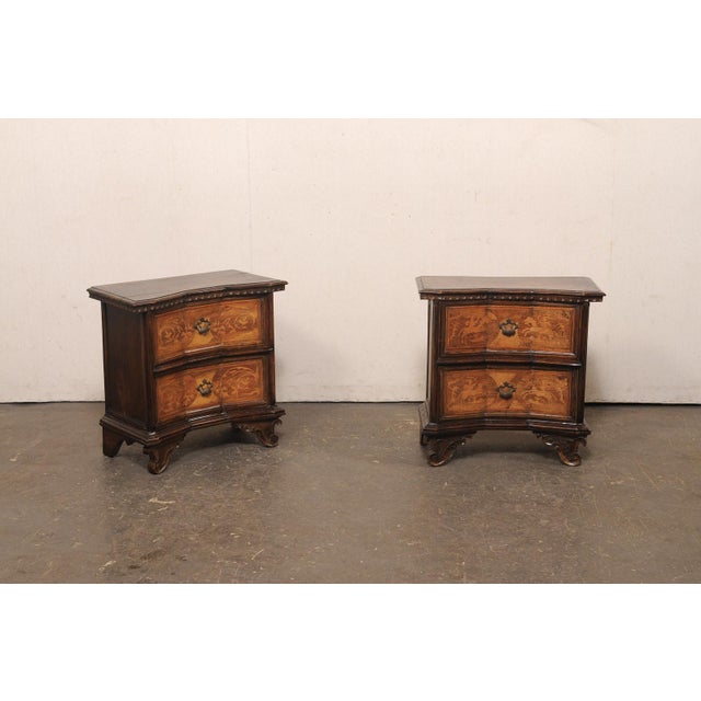 A handsome Venetian pair of petite side chests, with reverse-serpentine design and intricate inlay marquetry, from the...
