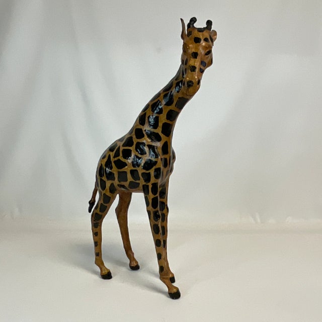 Offering a dramatic safari leather wrapped Giraffe tabletop figurine from the 1970s. This guy stands tall at 16.5” and...