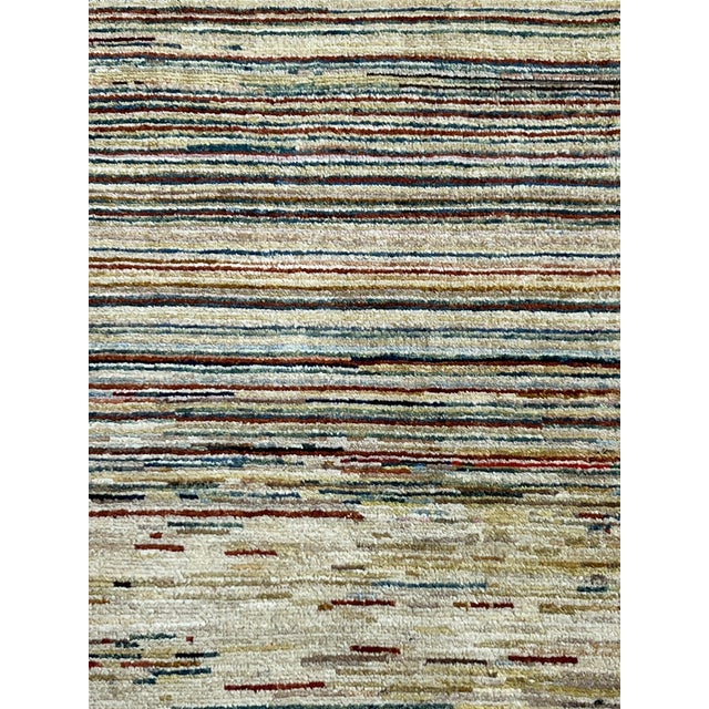 Afghan striped Gabbeh rug, hand-knotted in Afghanistan from 100% wool. Measuring 2’2” x 2’10”, the rug features a warm...