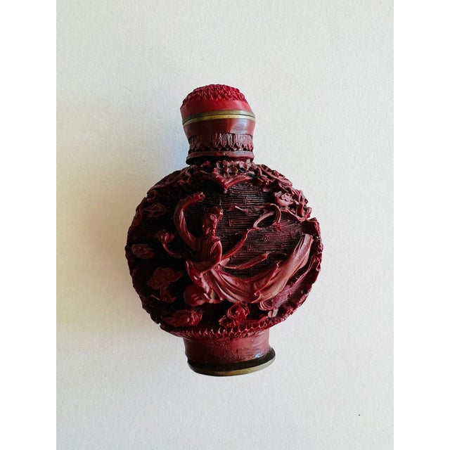 Vintage Carved Cinnabar Snuff Bottle with Qianlong Reign Mark A beautifully carved vintage cinnabar snuff bottle featuring...