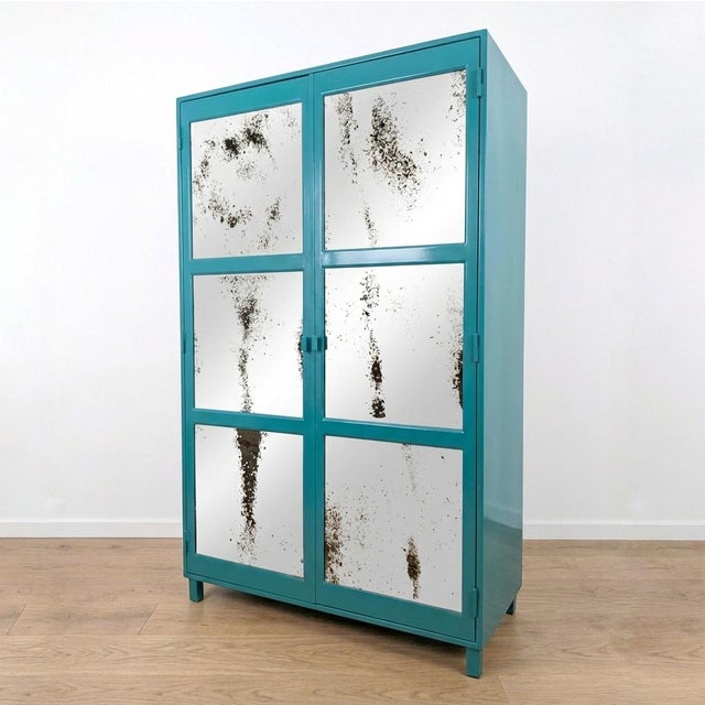 Vintage Industrial style metal wardrobe with a striking turquoise finish and aged mirror panels on the front of the double...
