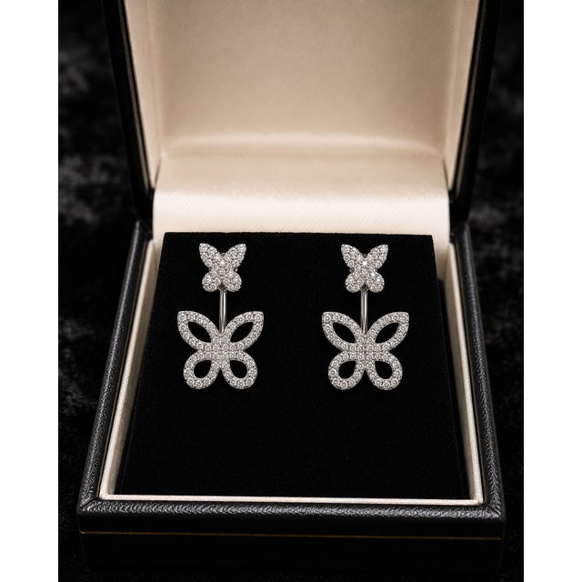Delicate in motif but bright in finish, these 10K White Gold butterfly earrings feature round natural diamonds arranged...