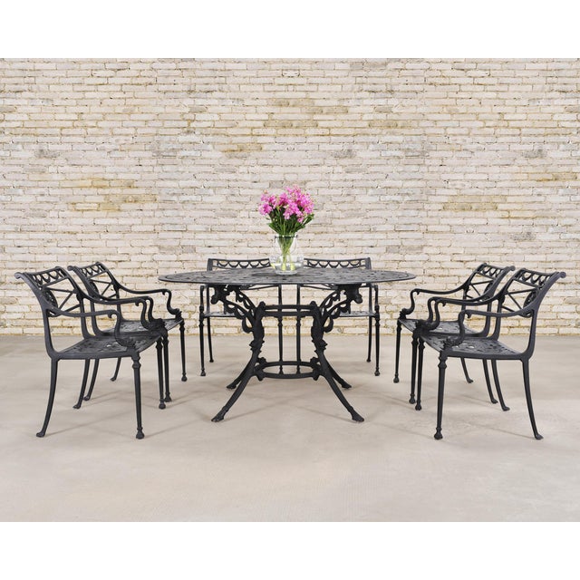 An elegant cast aluminum patio and garden dining suite comprised of six Star and Dolphin armchairs chairs (Model #FC20)...