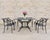 An elegant cast aluminum patio and garden dining suite comprised of six Star and Dolphin armchairs chairs (Model #FC20)...