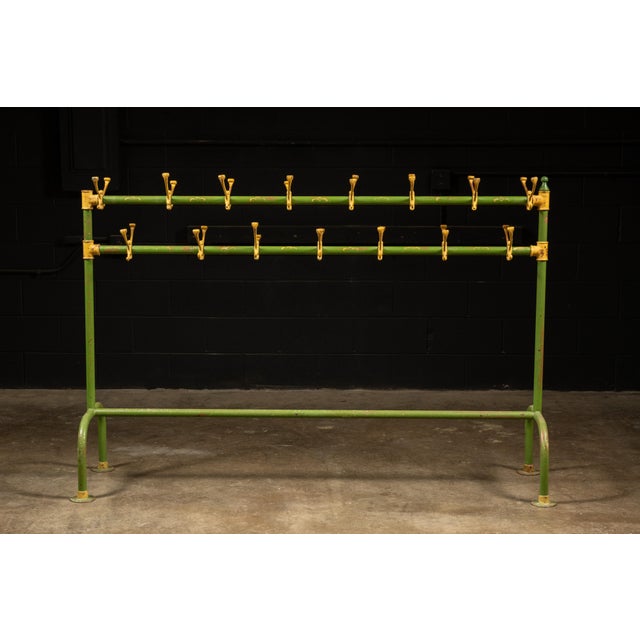 A large freestanding steel coat rack featuring 28 double-arm hooks mounted on two horizontal bars. The frame is finished...