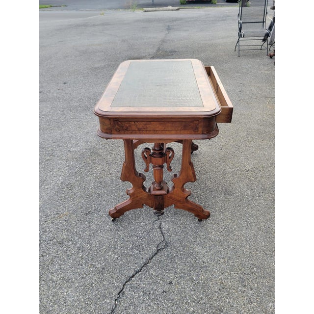 This 19th Century Victorian Walnut Renaissance Revival New Leather Table is a stunning piece of antique furniture. Fully...