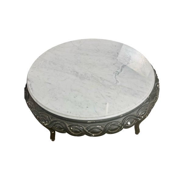 A round white marble top and an elaborately patterned black base give this vintage coffee table a striking two-tone...