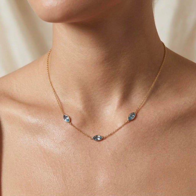 Cool down your style with this serene cluster pendant necklace, featuring three sparkling sky-blue gemstones set in an...