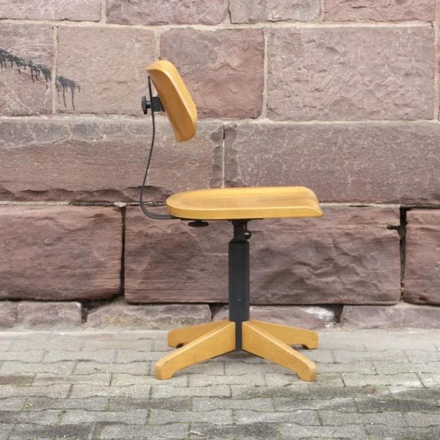 This vintage industrial office chair originates from between the 1950s and the 1960s. It is made from wood and metal and...