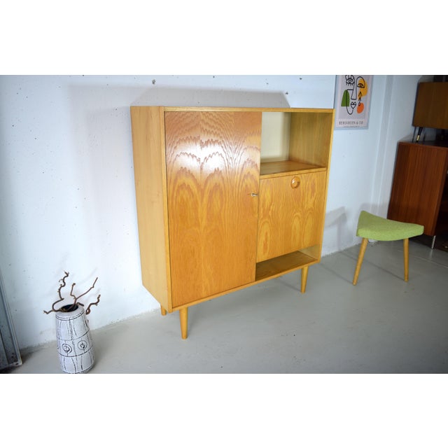 This is a beautifully designed bar cabinet with a chest of drawers from the 1970s, made by Hellerau Workshops. High-...