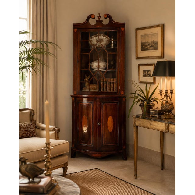 Elegant 19th-century English mahogany corner cabinet featuring classic Georgian-style design and refined decorative...