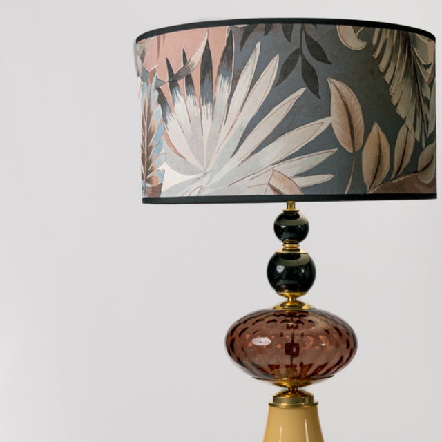 A pair of lamps made of Murano glass in yellow, pink, and black. The base of the structure is a rounded cone, and at the...