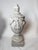 Stunning pair of cast concrete neoclassical urns adorned with floral garlands and floral final and round fluted base. A...