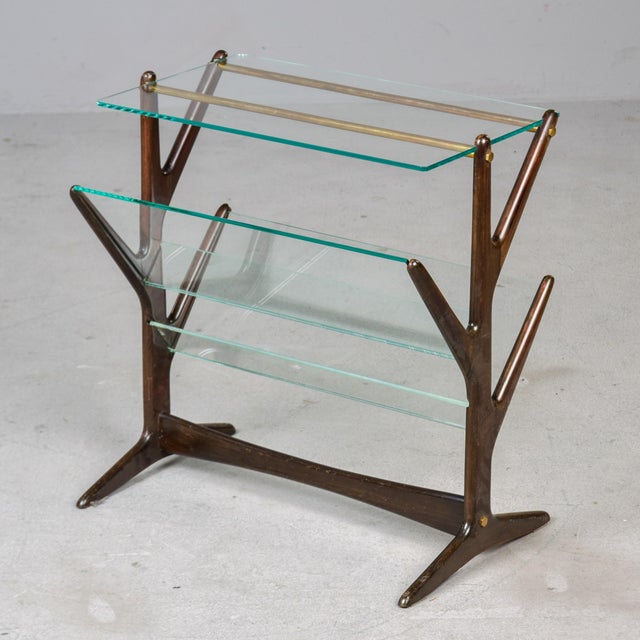 Found in Italy, this side table dates from the 1960s. The dark mahogany frame features brass hardware and inset clear...