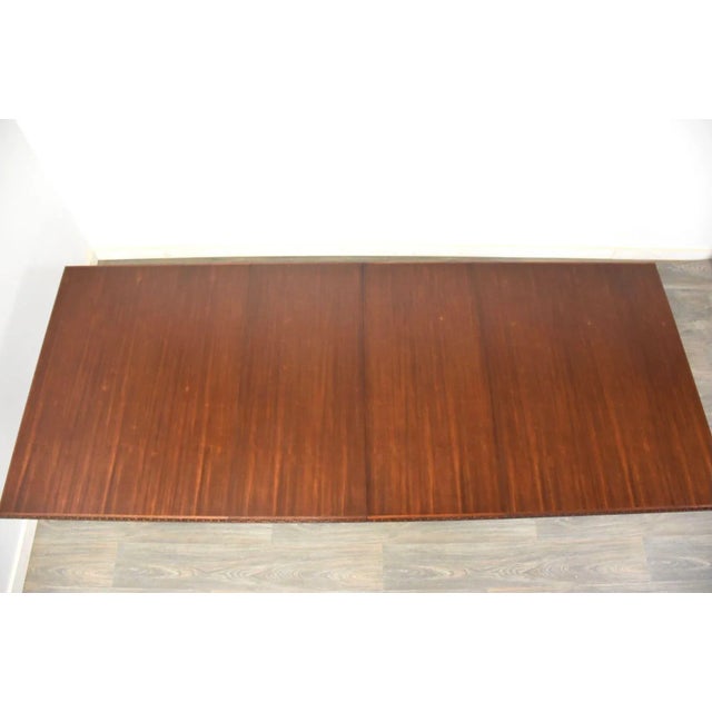 A beautiful mid century modern mahogany dining table designed by Frank Lloyd Wright for Henredon’s Taliesin line....