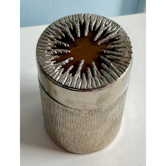 Vintage Global Views Nickel Tiger's Eye Canister is a decorative item that combines a sleek nickel finish with the unique...