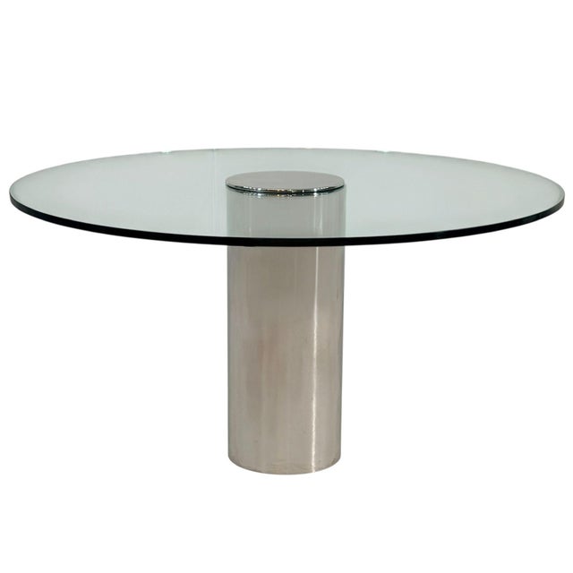 Brueton Chrome and Glass Cylindrical Pedestal Dining Table, 1980’s. Polished chrome base. Measures glass 44” diameter...