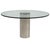 Brueton Chrome and Glass Cylindrical Pedestal Dining Table, 1980’s. Polished chrome base. Measures glass 44” diameter...
