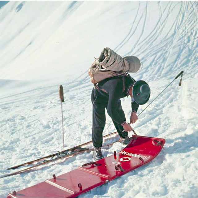 Mountain Top by Toni Frissell A member of the Klosters ski patrol checks a stretcher, Switzerland, 1951. (Photo by Toni...