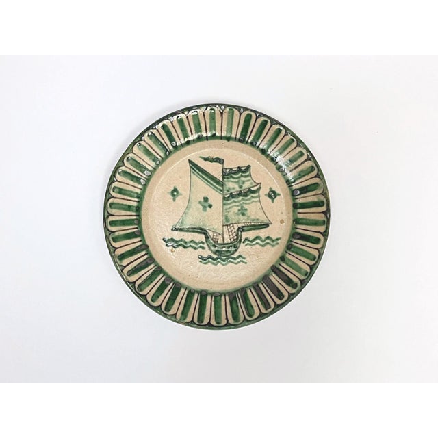 Four Vietri plates decorated in green with fish and caravels, Fabbrica Ceramica Avallone, 1930s. The plates are part of a...