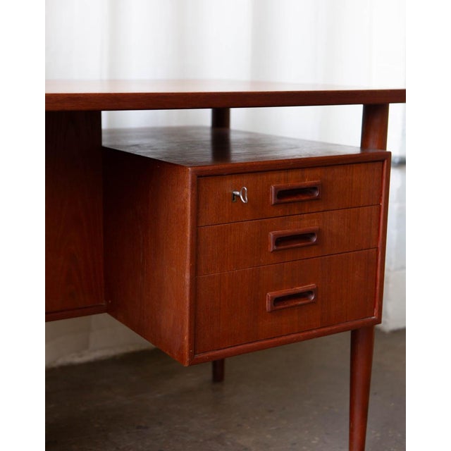 A refined Danish Modern writing desk by HP Hansen, produced in the 1960s during the height of Scandinavian furniture...
