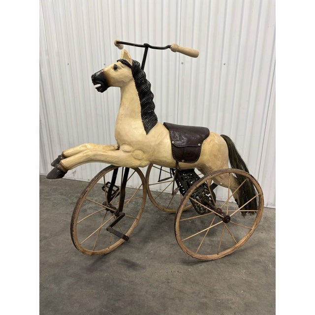 From an exquisite Chicago estate is a carved wooden child’s tricycle, early to mid 20th century. Wood body, tooled leather...