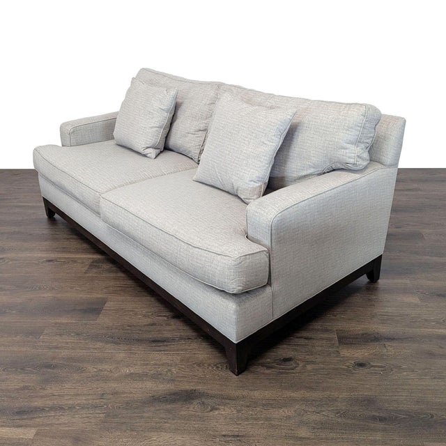 Features a wood base with tapered legs that anchors loose back and seat cushions and track arms. Brand: Ethan Allen....