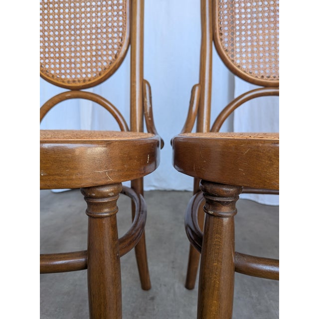 Set of 4 vintage bentwood dining chair in the classic Thonet style, featuring a high cane backrest and cane seat. Made in...