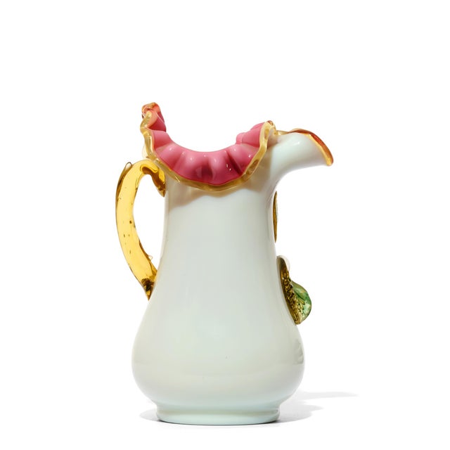 Sourced: Calabasas A striking vintage porcelain pitcher featuring three-dimensional applied floral appliqués in white and...