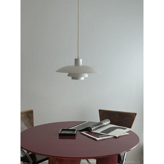When lit, the light bounces between the three nested shades before spilling softly into the room, a warm, diffused glow...