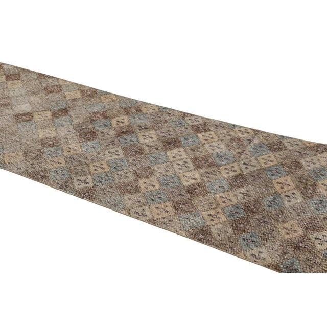 This vintage runner rug is a 3x11 Turkish distressed piece, made with hand-knotted wool circa mid-20th century. It is an...